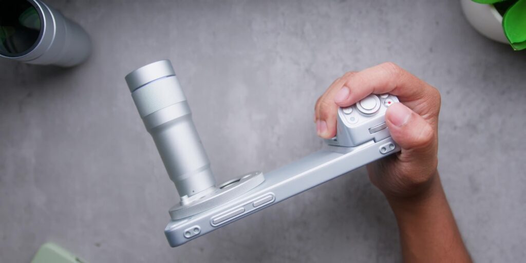 A user holding the vivo X300 Ultra with the bulky Zeiss telephoto extender attached to show scale.